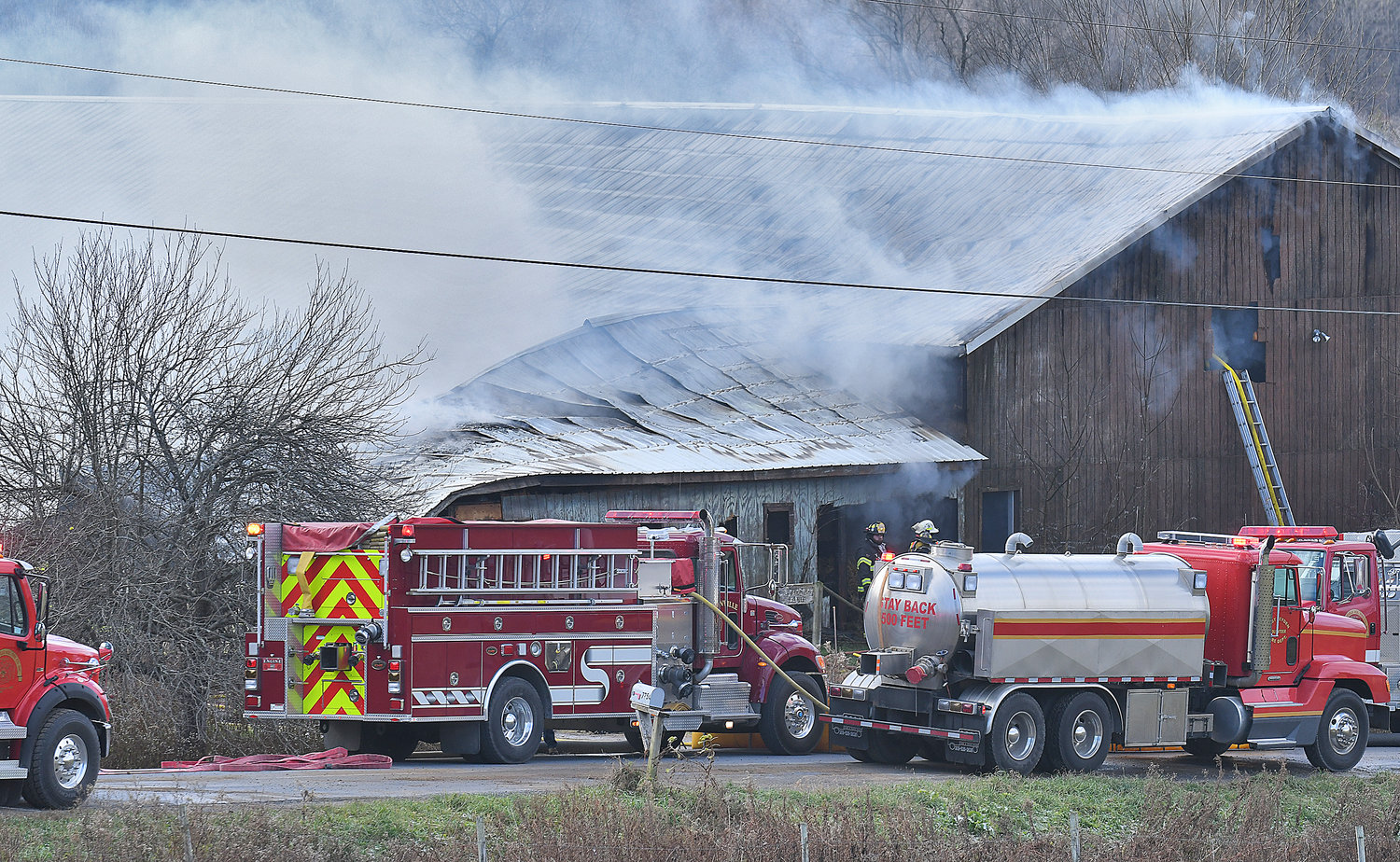 Firefighters from Boonville, Constableville, Westernville and West Leyden fire companies work a barn fire on Jackson Hill Road near the Merry Hill Road intersection in the Town of Ava Monday morning. Due to a lack of water, firefighters utilized portable water tankers and a nearby pond to battle the blaze.