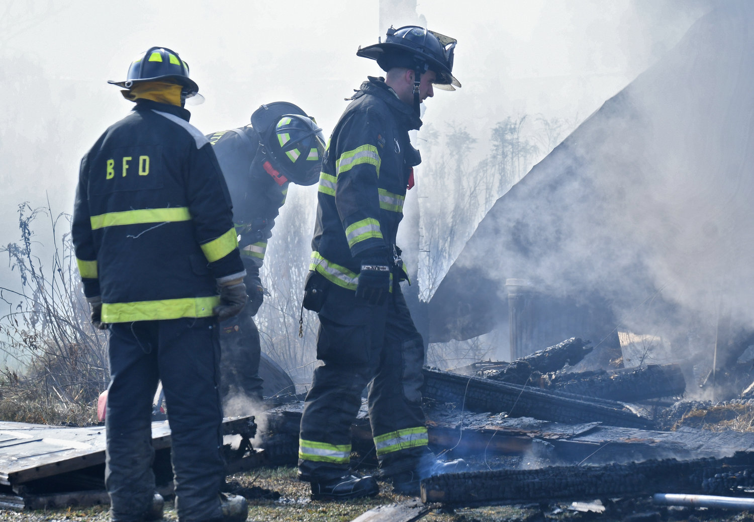 Members of Boonville Fire Department pick through the charred remains of collapsed framework of a barn destroyed by flames on Jackson Hill Road in Ava Monday morning. The alarm rang for 7754 Jackson Hill Road shortly before 8:30 a.m.