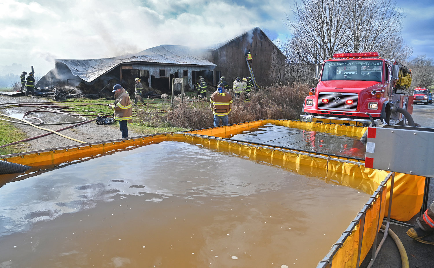 Firefighters from Boonville, Constableville, Westernville and West Leyden fire companies work a barn fire on Jackson Hill Road near the Merry Hill Road intersection in the Town of Ava Monday morning. Due to a lack of water, firefighters utilized portable water tankers and a nearby pond to battle the blaze.