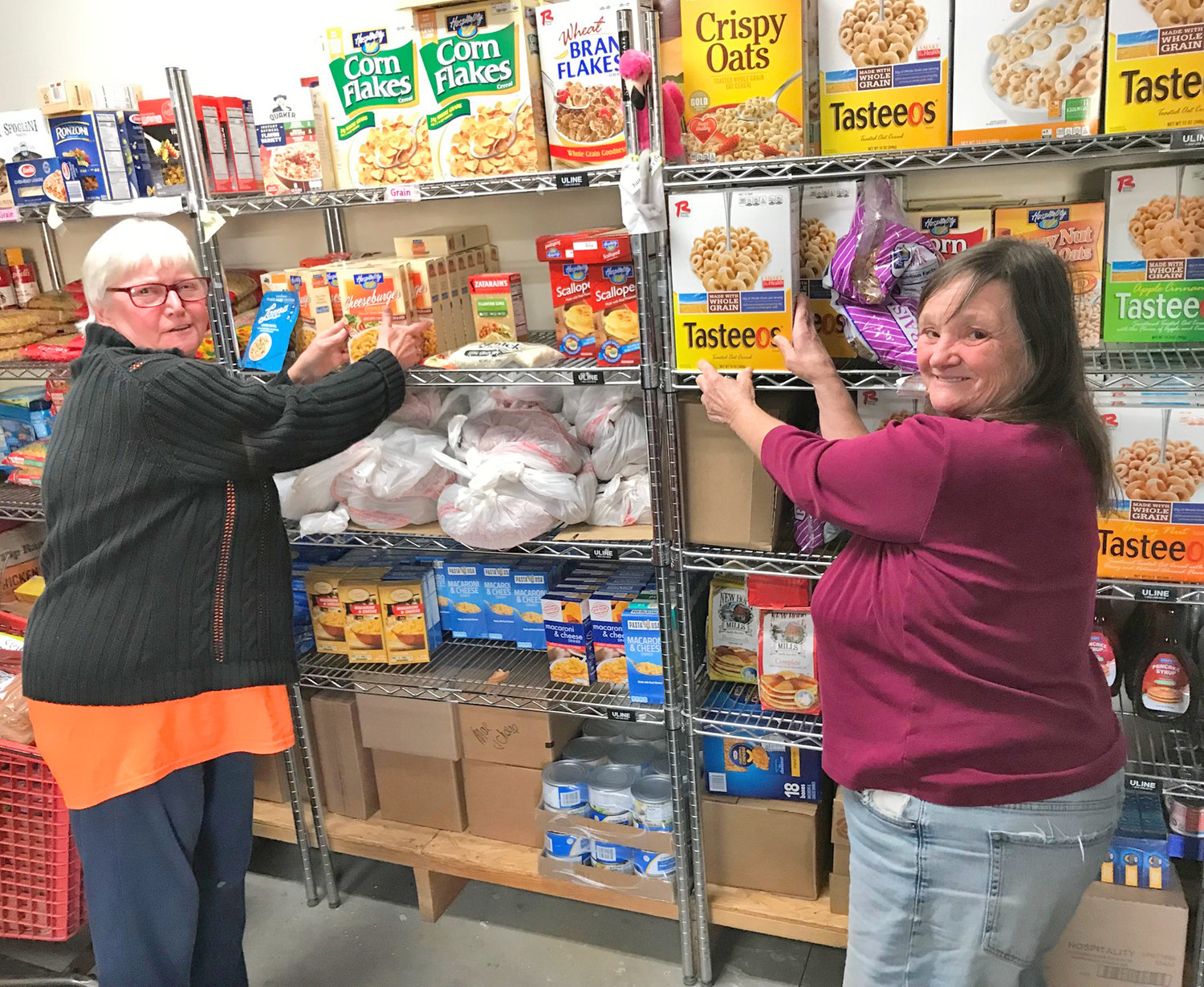 Verona Food Pantry volunteers Sue Wilcox, left, and Becky Harrington pose Nov. 3 with some of the many offerings at the community food source for those in need.