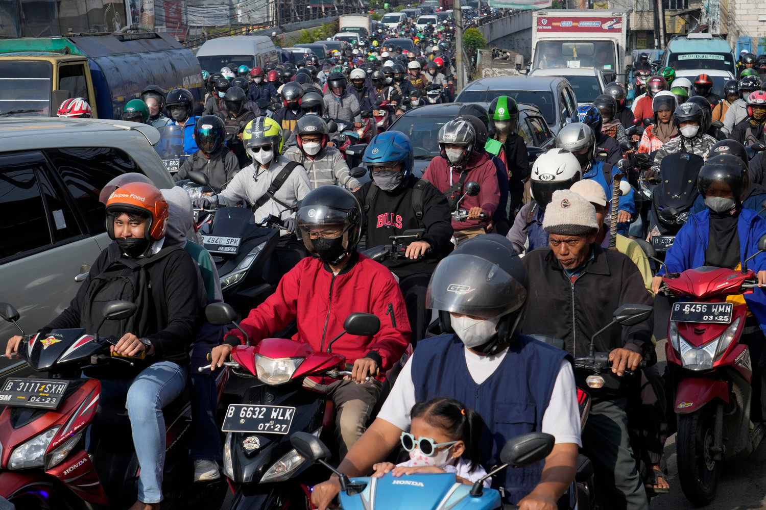 Motorists are stuck in the morning rush hour traffic in Jakarta, Indonesia, Monday, Nov. 14. The 8 billionth baby on Earth is about to be born on a planet that is getting hotter. But experts in climate science and population both say the two issues aren’t quite as connected as they seem.