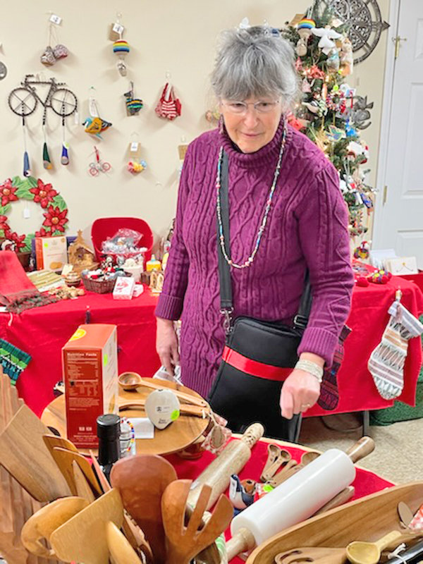 Lauralyn Kolb, director of the Fair Trade Shop at Stone Presbyterian Church in Clinton, shows off some of the decorative rolling pins and wooden cooking utensils made from olive wood that are among the items from 38 different countries available at the store.