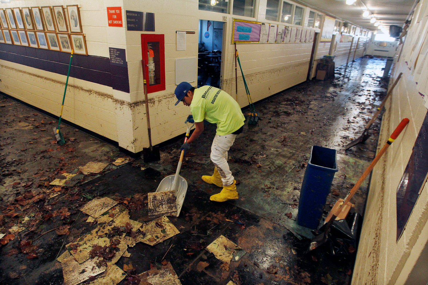 FILE - A worker scrapes up mud and tiles from flood-damaged Saint Rose High School in Belmar, N.J., on Nov. 4, 2012, after storm surge caused by Superstorm Sandy. 90% of counties in the United States experienced a weather-related disaster between 2011-2021, according to a report published on Wednesday, Nov. 16, 2022. Over 300 million people ‚Äî 93% of the country‚Äôs population ‚Äî live in those counties. (AP Photo/Mel Evans, File)