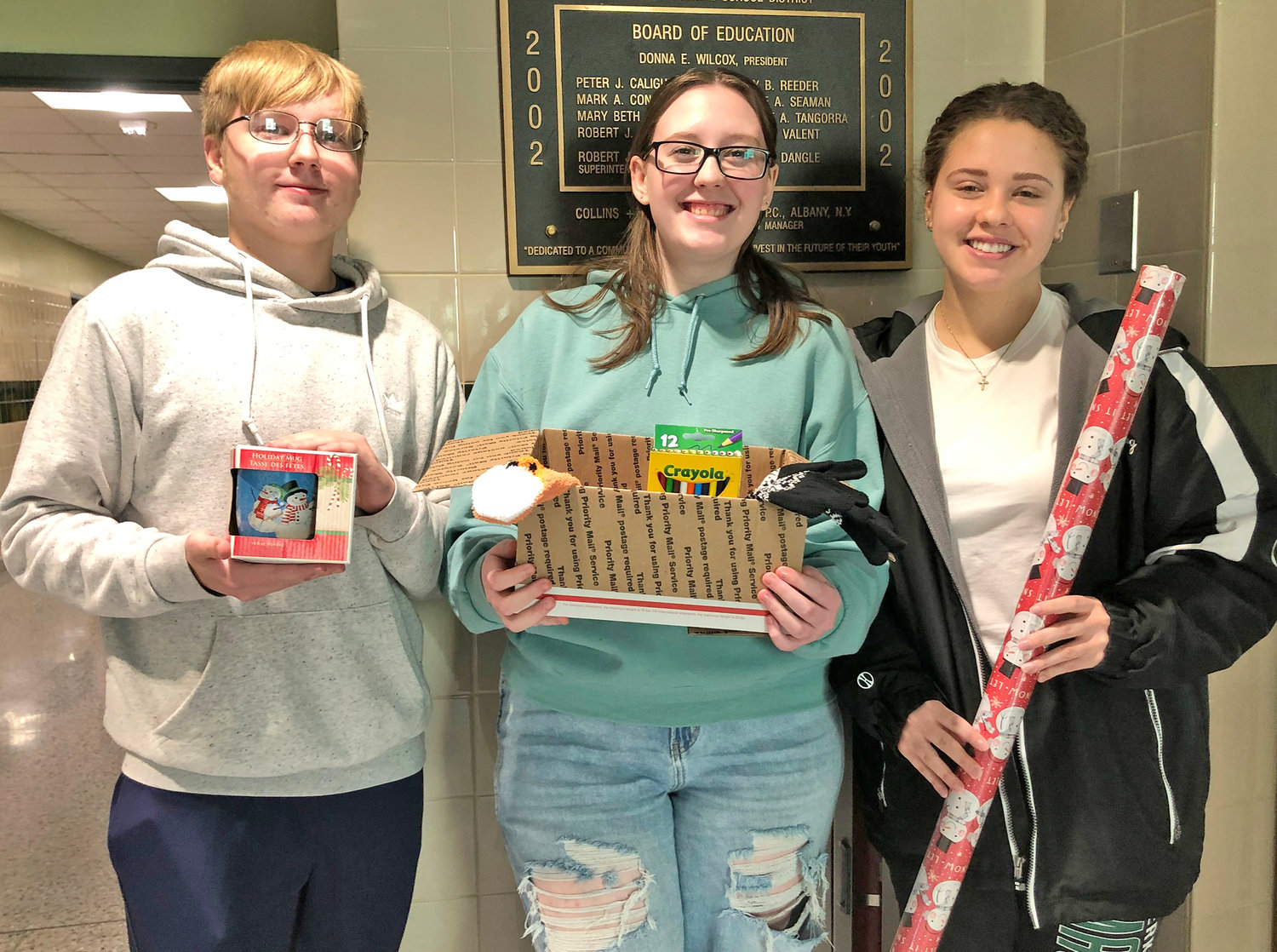 Herkimer Central School District National Junior Honor Society President Brian Flint, left, National Honor Society President Lilliana Langdon, center, and Student Council President Izabella Vredenburg pose with items for the annual Holiday Project.
