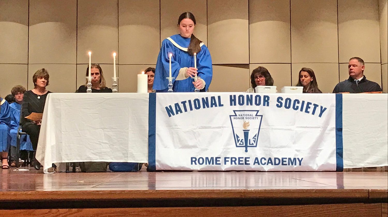 National Honor Society Treasurer Abigail Bates lights the final of four candles Monday during the new member induction ceremony at Rome Free Academy.