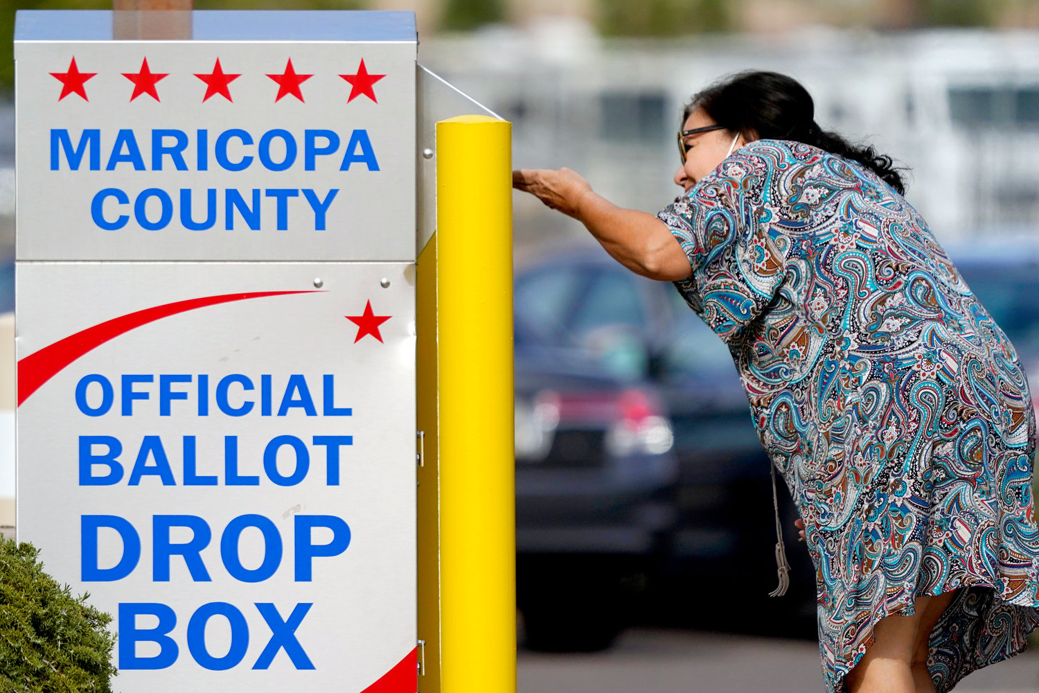 A voter drops off her ballot at a drop box, Nov. 7, in Mesa, Ariz. Fears of aggressive poll watchers sowing chaos at polling stations or conservative groups trying to intimidate votes didn’t materialize on Election Day as many election officials and voting rights experts had feared. Voting proceeded smoothly across most of the U.S., with a few exceptions of scattered disruptions.