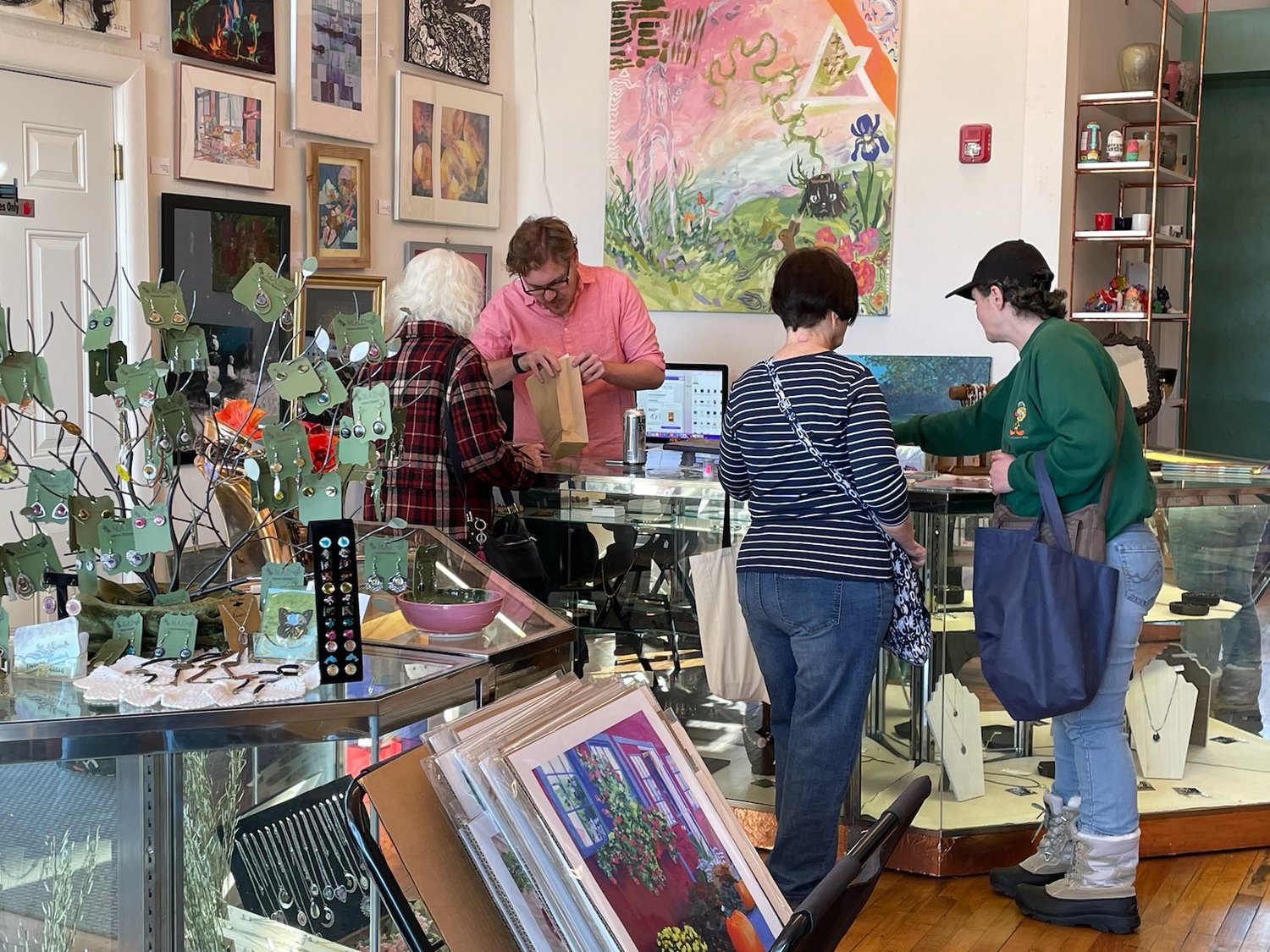 Adam Prescott Chrisman, owner of The Copper Easel, waits on some customers during the Small Business Saturday event in Rome's Downtown Arts District.