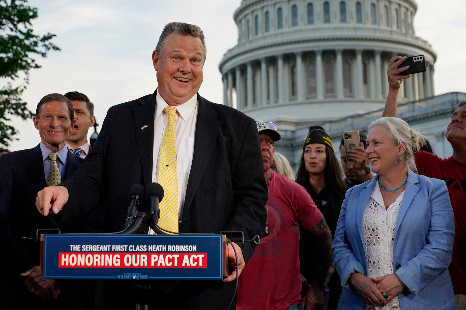 Sen. Jon Tester, D-Mont., speaks at a news conference alongside Sen. Richard Blumenthal, D-Conn., back left, and Sen. Kirsten Gillibrand, D-N.Y., after the Senate passed a bill designed to help millions of veterans exposed to toxic substances during their military service, Aug. 2, 2022, on Capitol Hill in Washington.