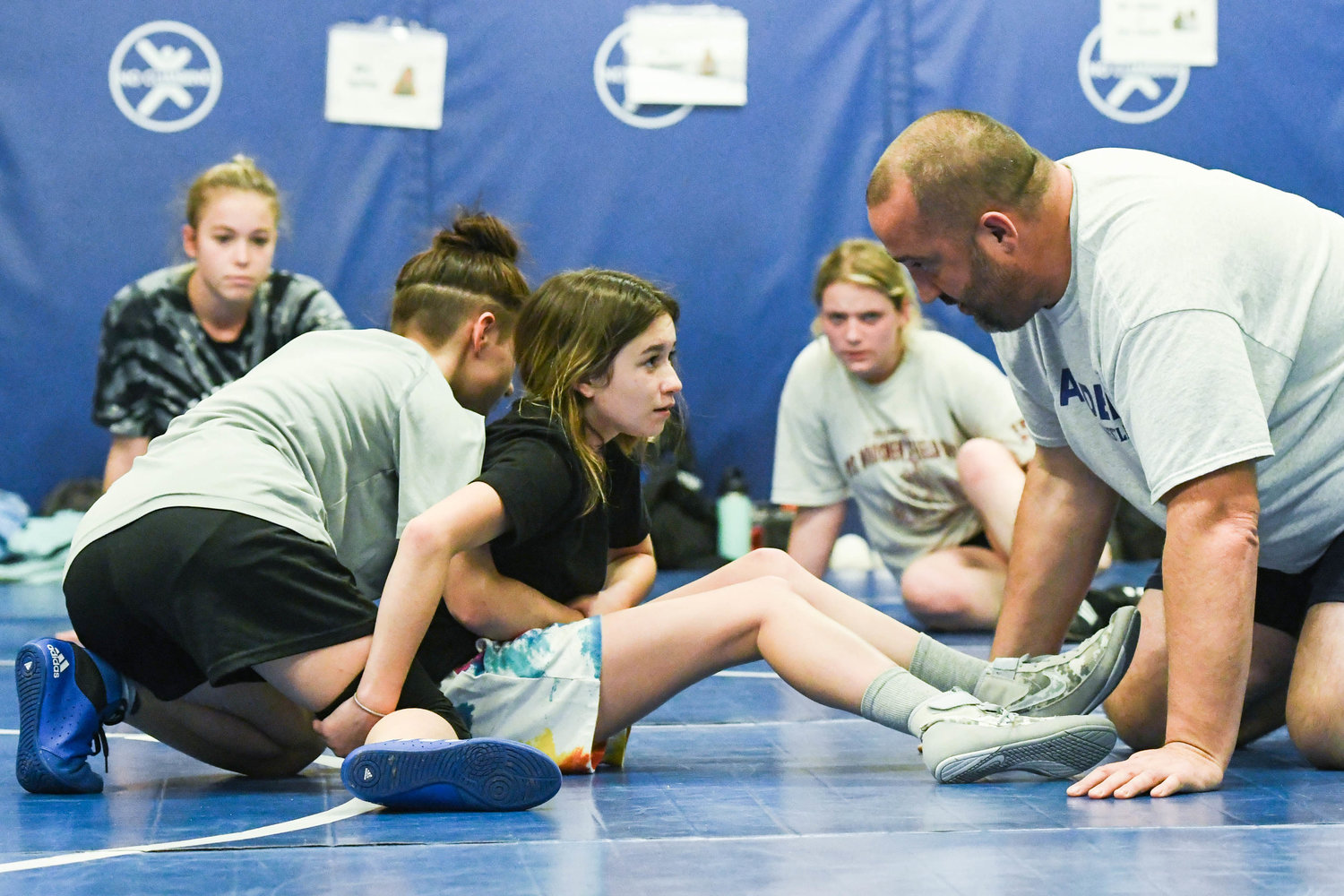 Camden head coach Jeremy Calkins helps wrestlers Hailee Evans and Madelyn Baker during practice on Monday at Camden Elementary School.