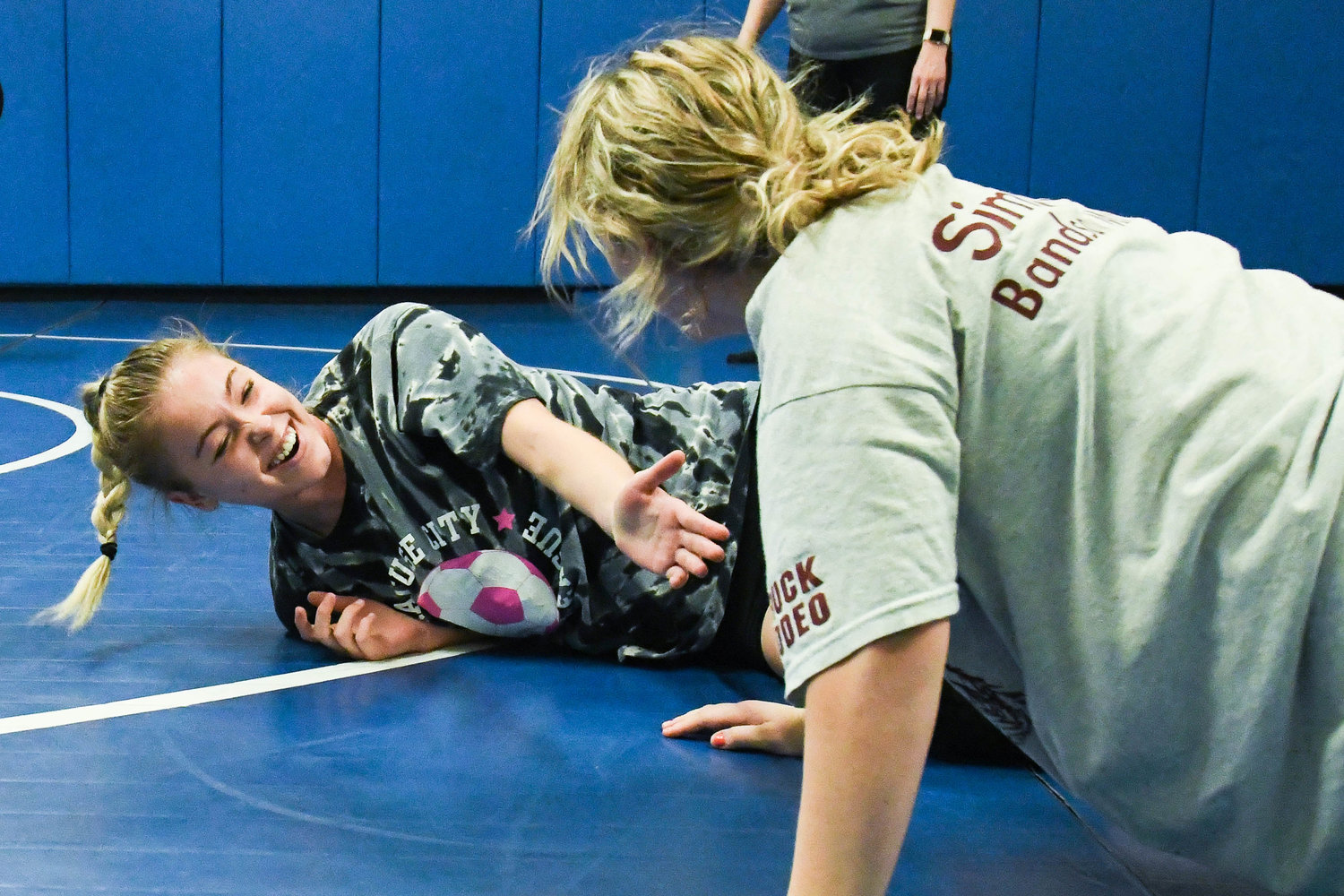 From left, Camden wrestler McKenzie Aldridge shares a laugh with Megan Trautner after getting taken down hard to the mat during practice on Monday at Camden Elementary School.