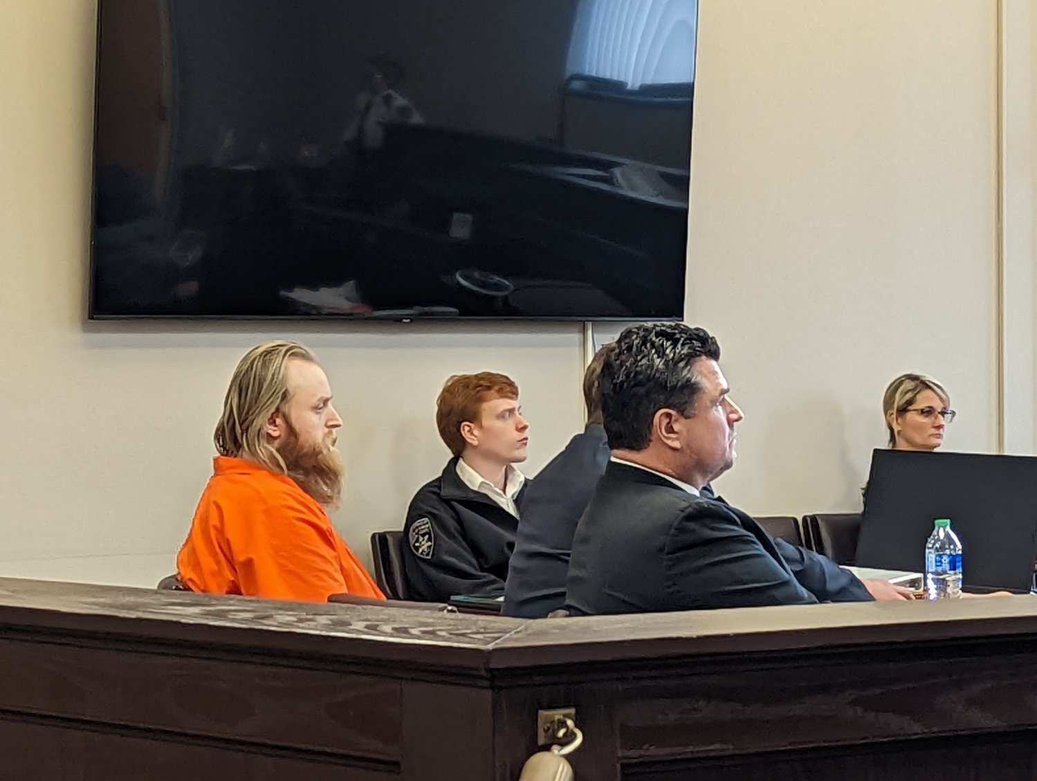 Accused killer Matthew Westcott sits with his defense team at the first day of his trial on Monday in Oneida County Court. He is accused of shooting and killing his older brother at their family home in Taberg in September 2021. Westcott has chosen not to dress in civilian clothing, as was offered, and instead wore his orange Oneida County Jail jumpsuit on Monday.