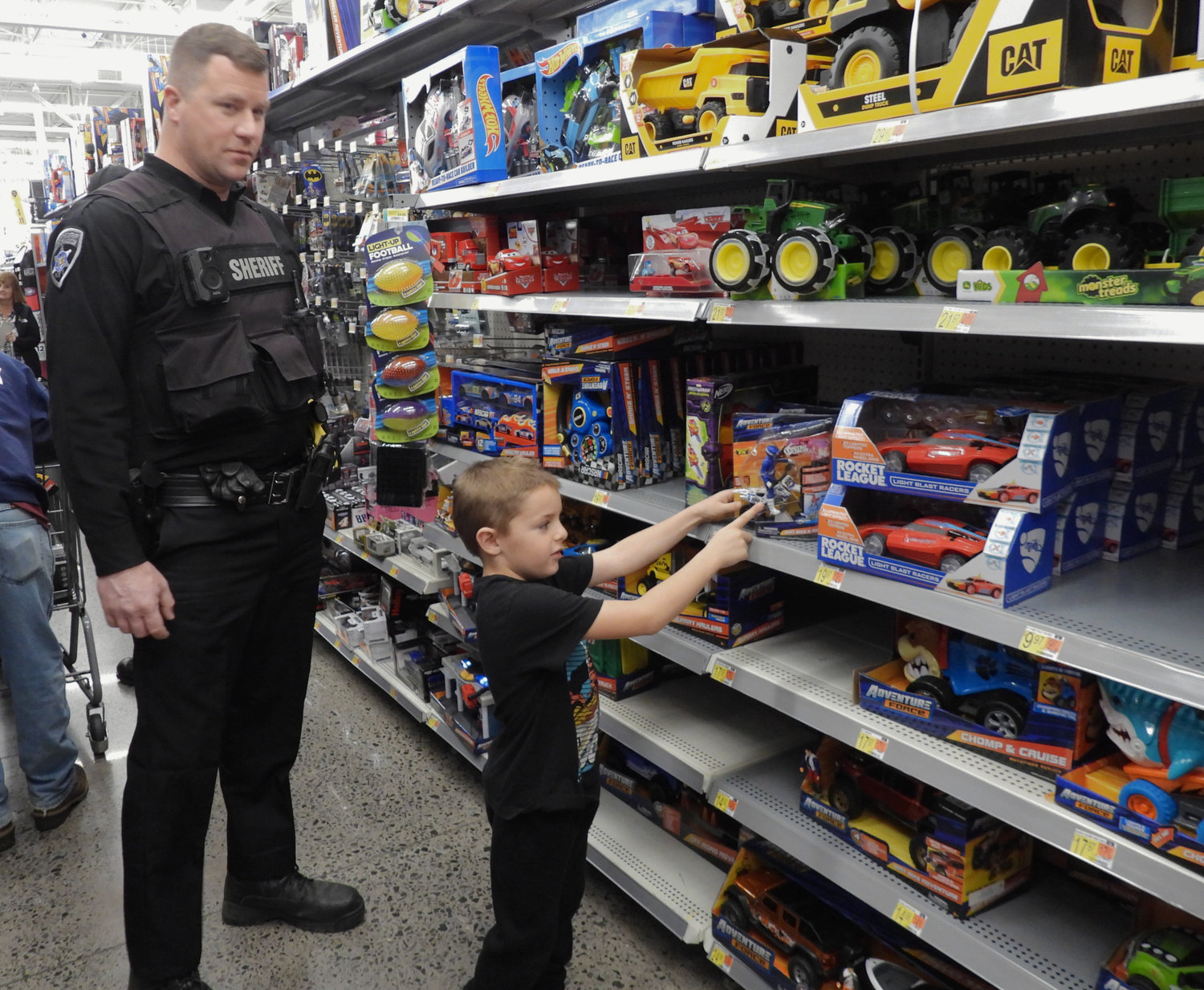 Seth Wheeler Jr., 6, a student of Burton Street Elementary School in Cazenovia, participates in Shop with a Sheriff on Saturday, Dec. 3, alongside Deputy Sheriff Steve Markle.