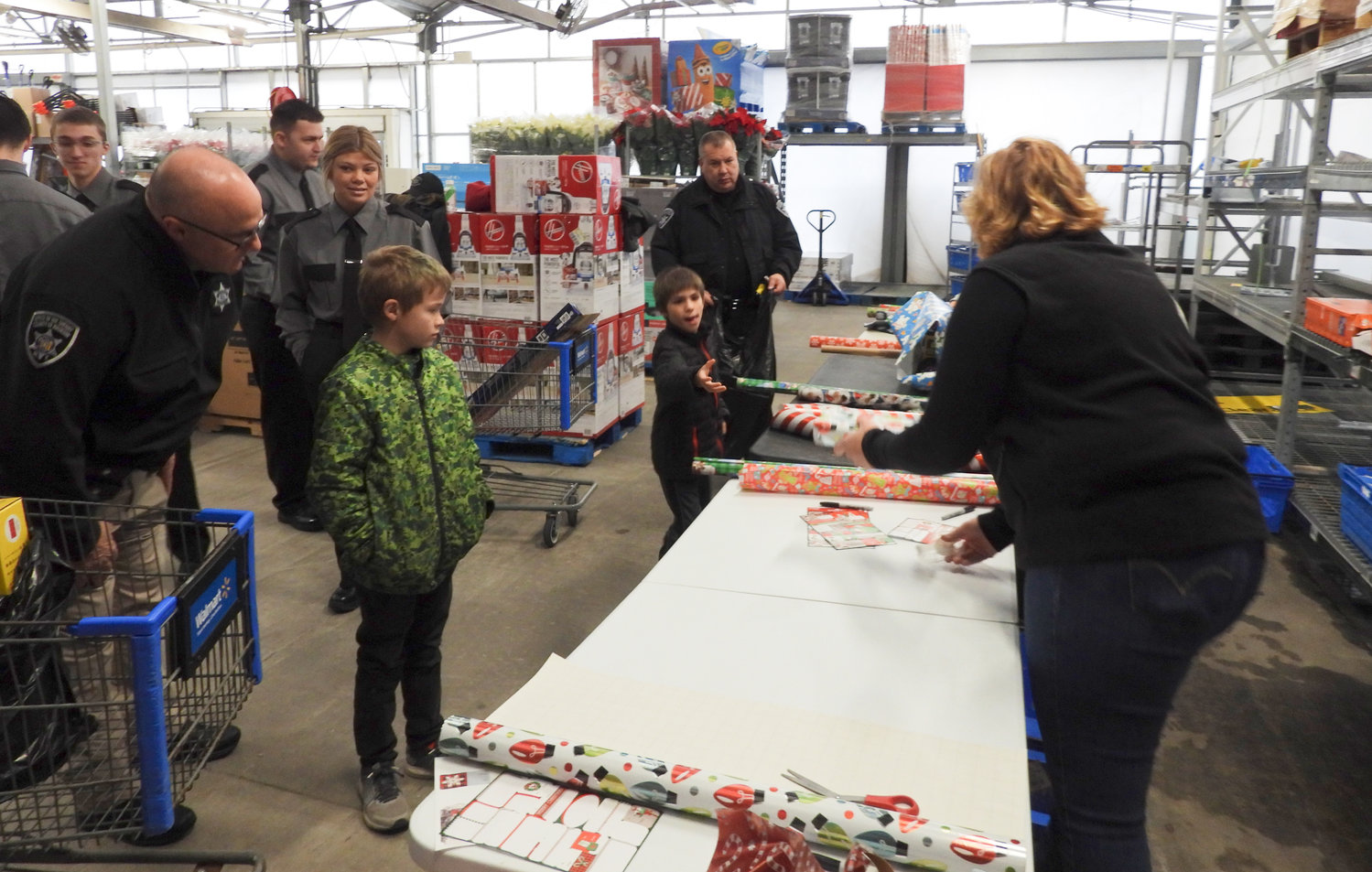 Presents are wrapped at the Madison County Shop with a Sheriff event on Saturday, Dec. 3