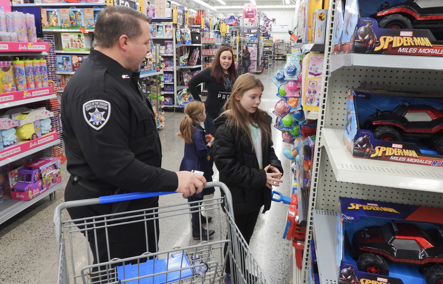 Ashlee Shanahan, 9, of Munnsville, shops with Deputy Kenneth Gates for the Madison County Shop with a Sheriff event on Saturday, Dec. 3