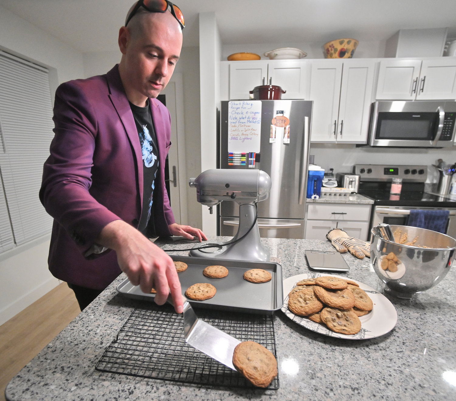 James Daino transfers chocolate chip cookies from the cookie sheet to the cooling rack Nov. 9 in his Rome kitchen. Daino has just been eliminated after a long run in the Bake from Scratch magazine 2022 Greatest Baker competition.