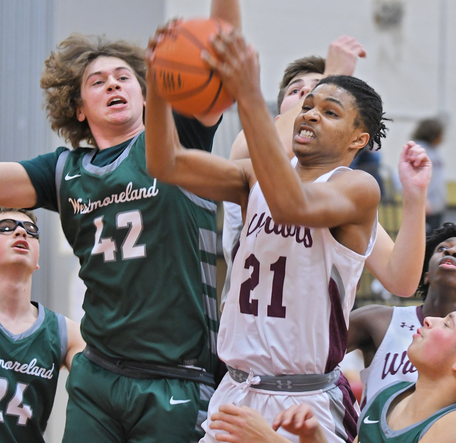 Clinton’s Trevor Forde muscles into the paint defended by Westmoreland’s Mitchell Holmes in the first quarter Thursday. The Warriors got a 65-42 home win over the Bulldogs.