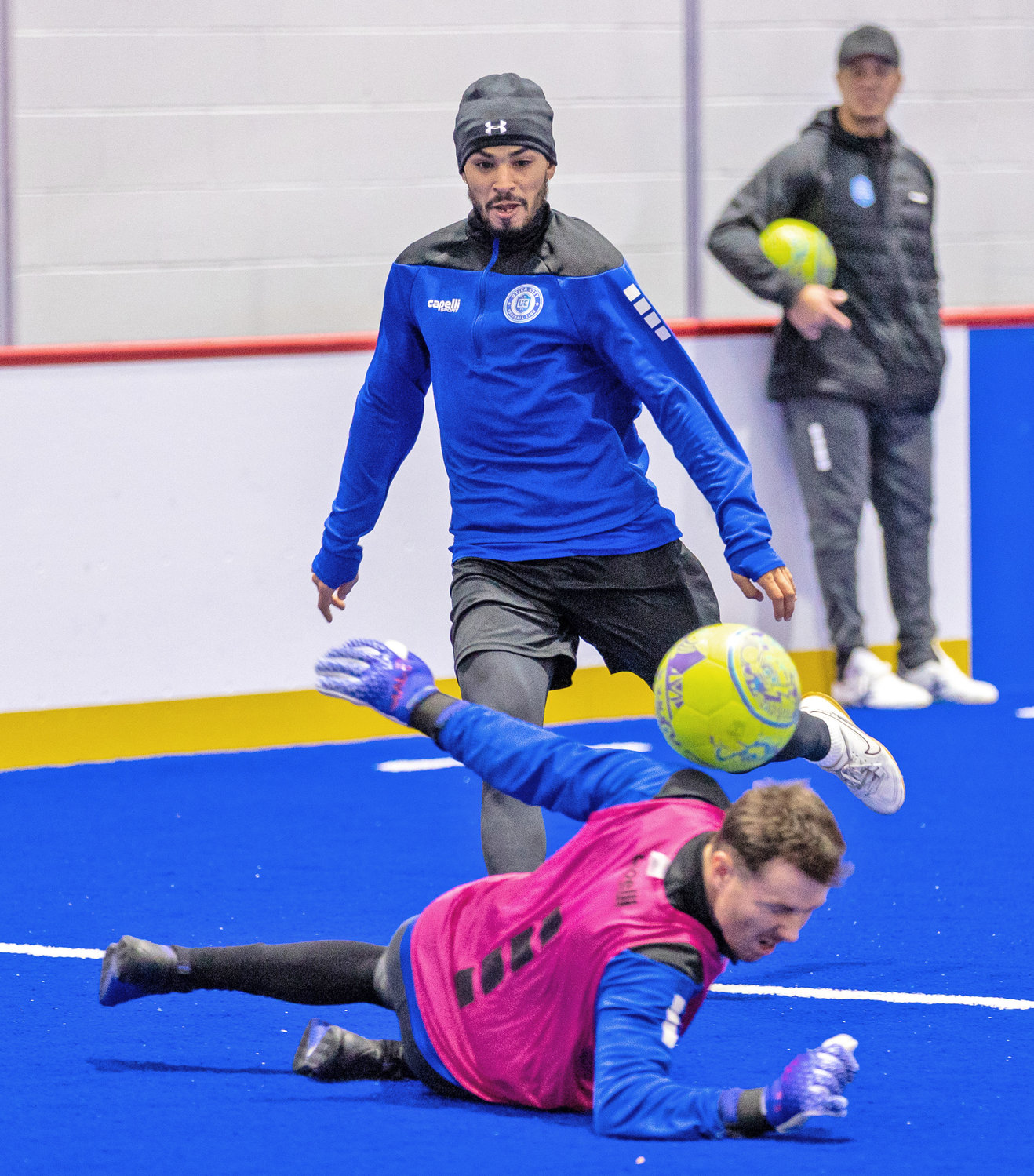 Forward Steven Fernandez watches as goalkeeper Brian Wilkin makes a save in practice for Utica City FC earlier this week. Looking on in the background is Hewerton Moreira, the team's new head coach.