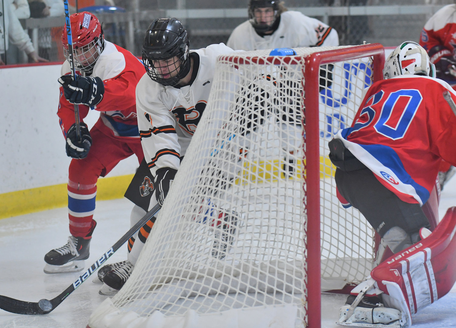 RFA's Tyler Wilson skates behind New Hartford goalie Michael Vetter with New Hartford's Rowan Gall chasing in the first period Friday night at Kennedy Arena.