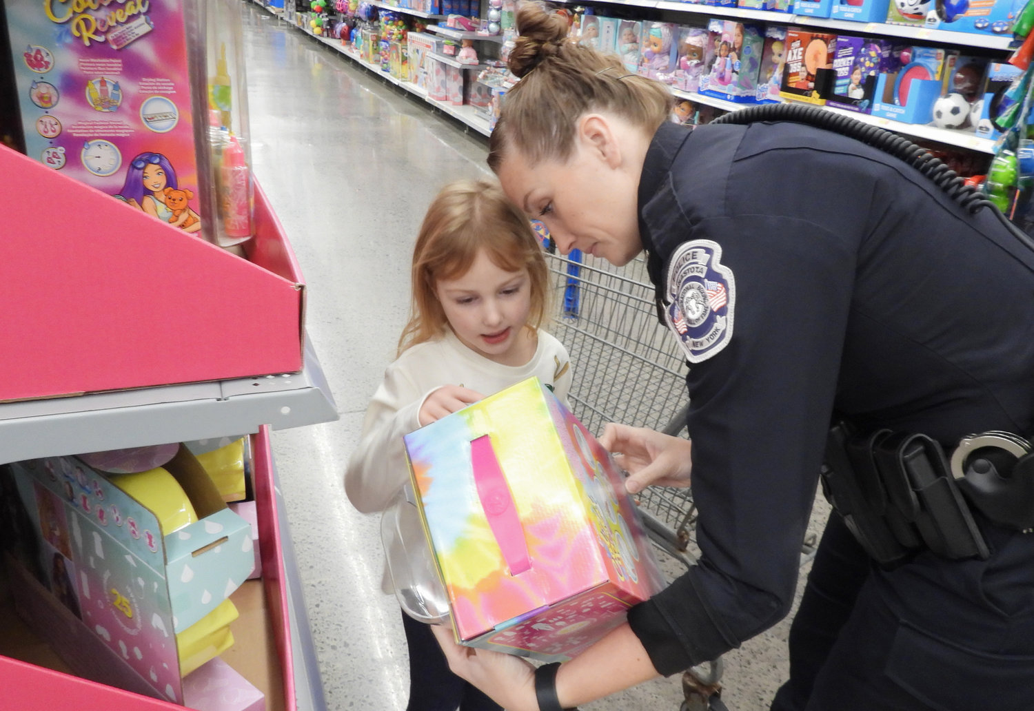 More than 80 children got a chance to shop with a cop at the Oneida Police Department's annual Shop with a Cop, where they got to meet and talk with local police officers while shopping for everything on their Christmas list. Pictured is five-year-old Olivia Boncella, shopping with Officer Cassandra Dailey with the Canastota Police Department.
