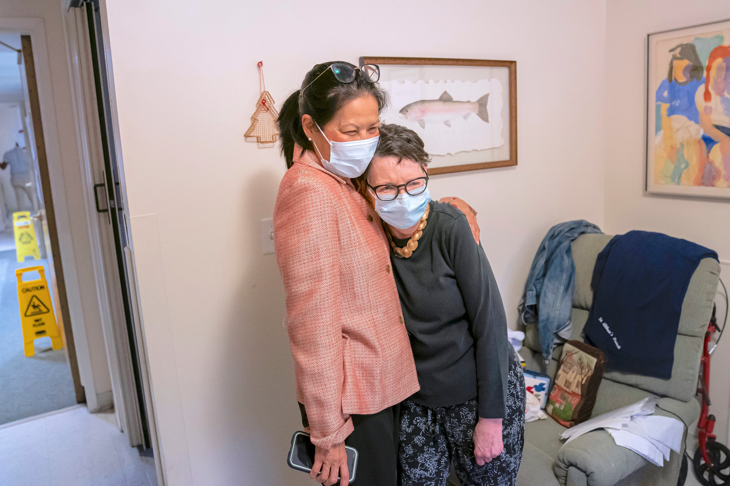 Tina Sandri, CEO of Forest Hills of DC senior living facility, left, hugs resident Courty Andrews after helping Andrews back to her room on Thursday, Dec. 8, in Washington.