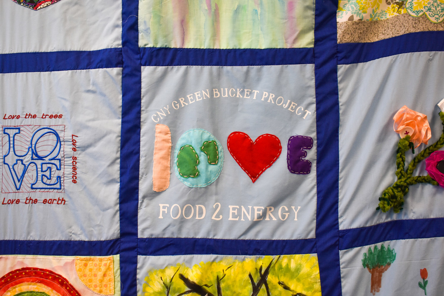 A quilt at the CNY Green Bucket Project’s office, 4340 Middle Settlement Road, New Hartford, is made up of squares featuring clients’ designs.