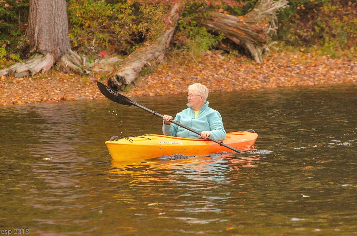 Sue Kiesel paddles the kayak to her favorite spot on the lake to take pictures of wildlife near Old Forge.