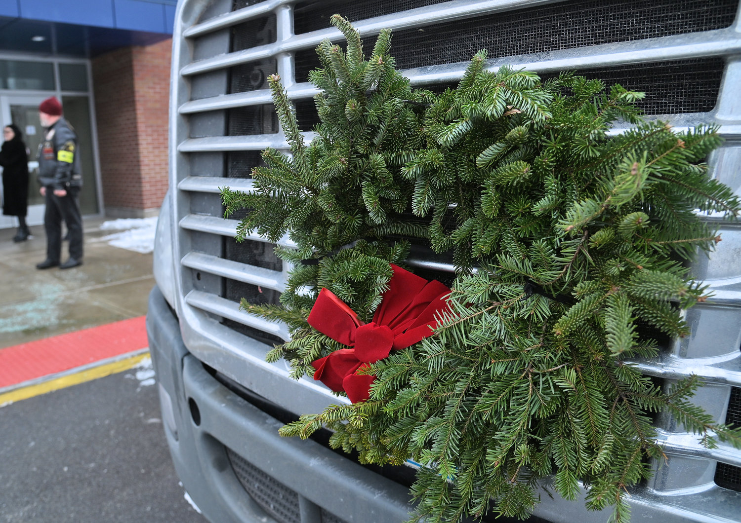 A wreath is seen on the grill of the Walmart truck parked in front of Notre Dame Jr.-Sr. High School Monday, Dec. 12. The trailer is full of wreaths for Wreaths Across America distribution this coming Saturday.