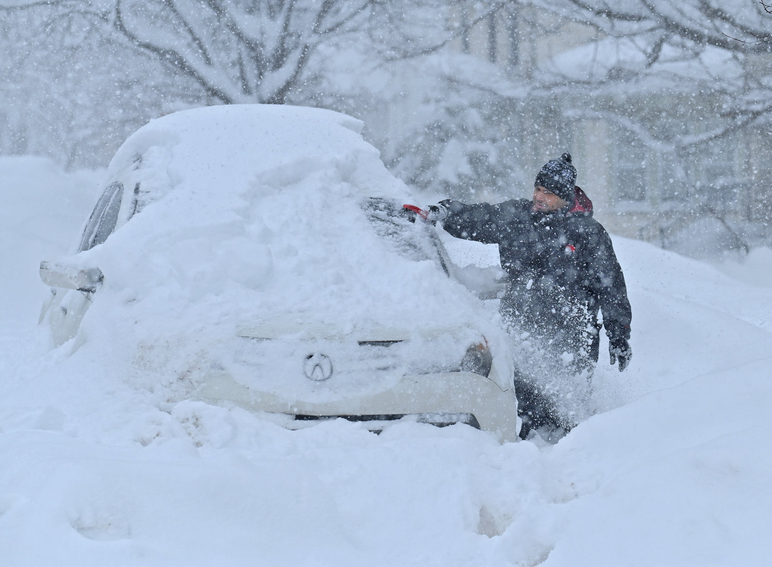 Paul Miranda 9642 Main St. cleans off his car during the big snowstorm in Remsen Monday, December 19, 2022.