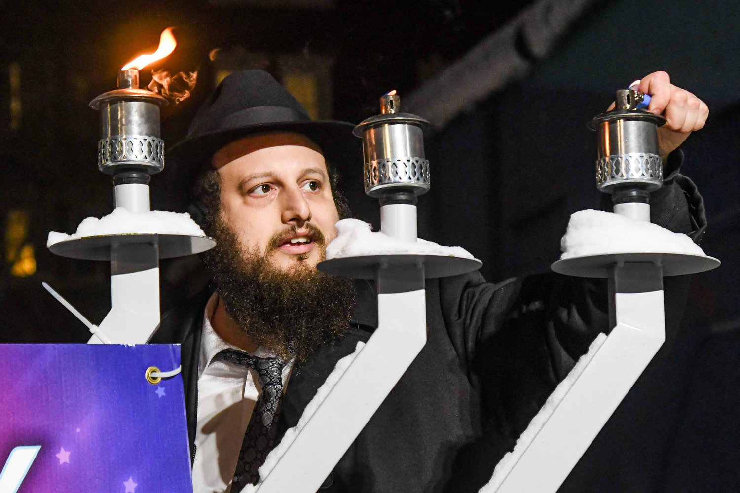 Rabbi Levi Yitzchok Charitonow from the Chabad of the Mohawk Valley lights a large menorah outside of Liberty Bell Park in celebration of Hanukkah on Tuesday, Dec. 20 in Utica.