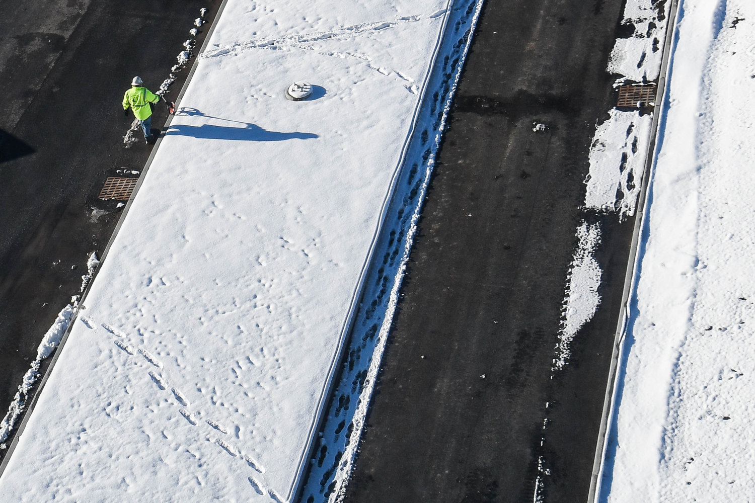 A construction worker measures out a section of the parking lot at the Wynn Hospital in Utica.