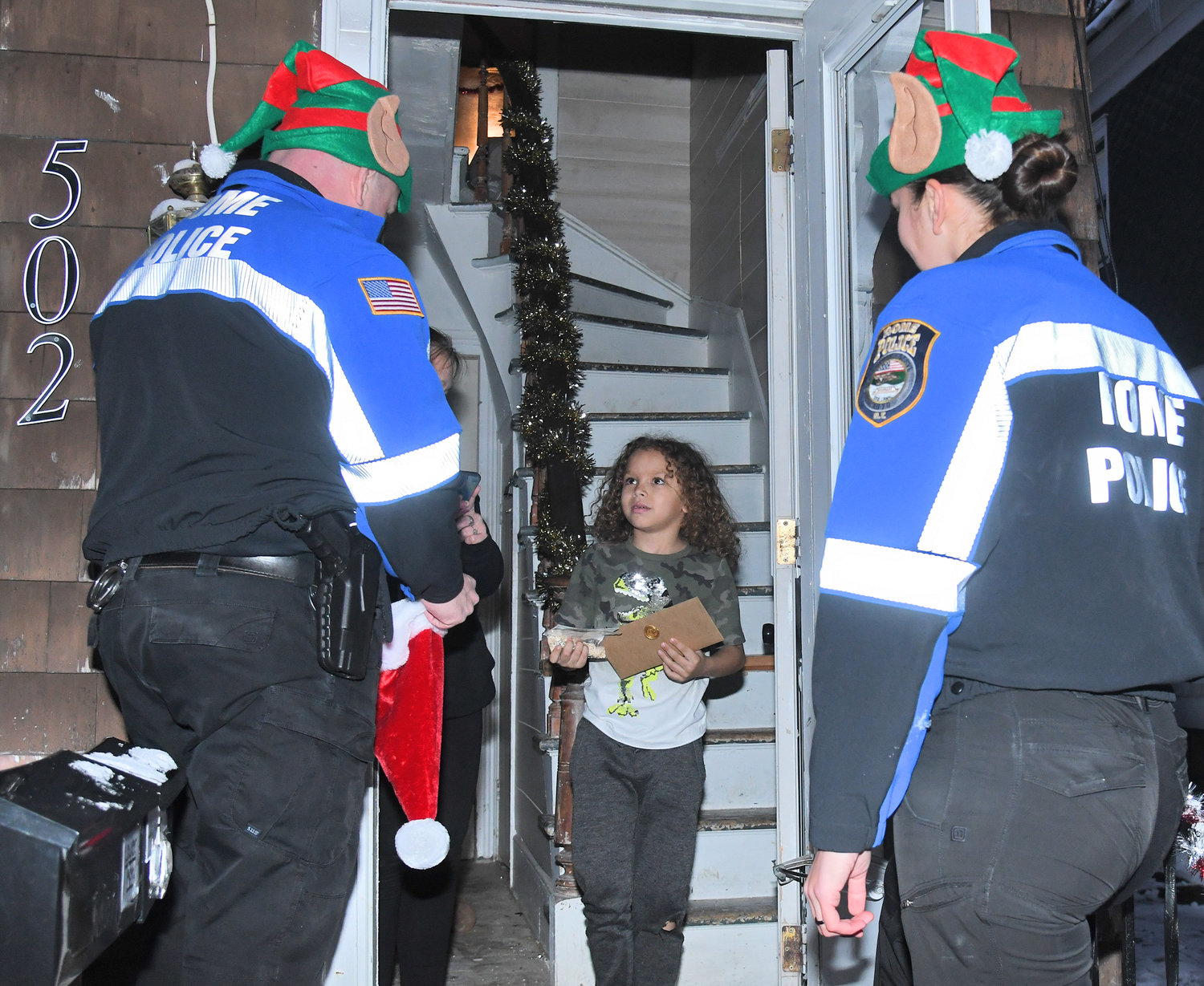 Niko Boyer, age 8, is all smiles during a visit from Rome Police officers Jenna Kiskiel and Anthony Calandra. Boyer had delivered his letter to Santa at the Rome Police station this year, and the officers dropped off Santa's response. Boyer was joined by his grandmother, Mary Boyer.