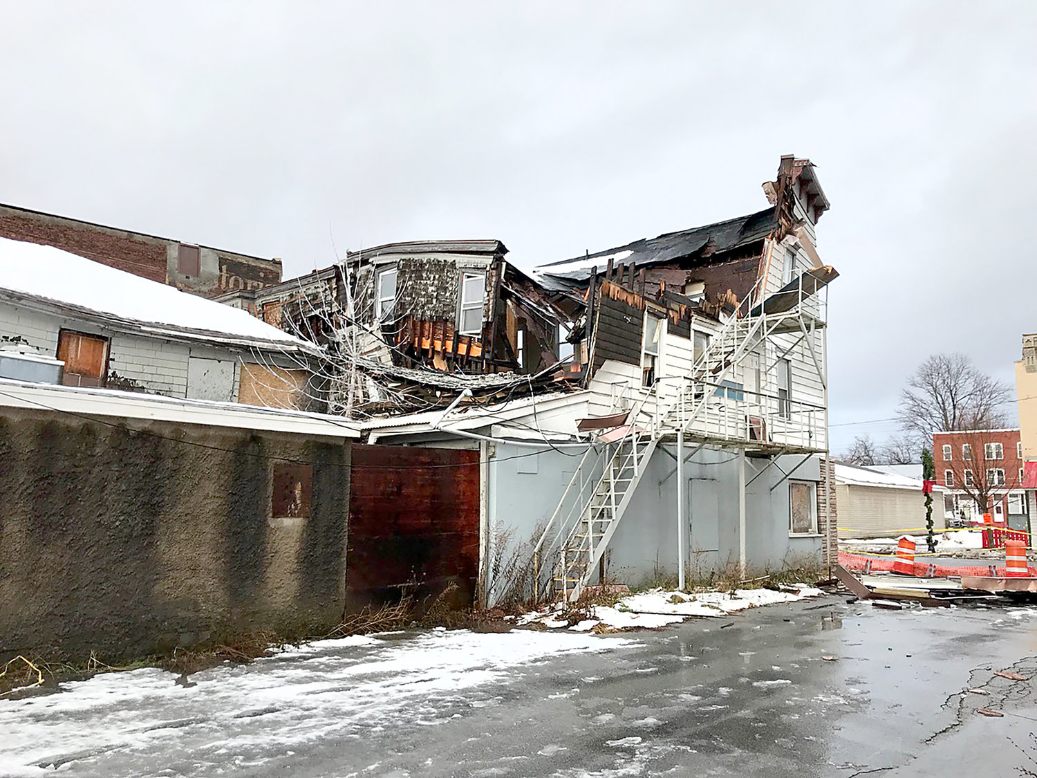 A fire escape seems to be supporting the remaining structure Friday morning on Madison Street in Oneida after much of the building collapsed Thursday.