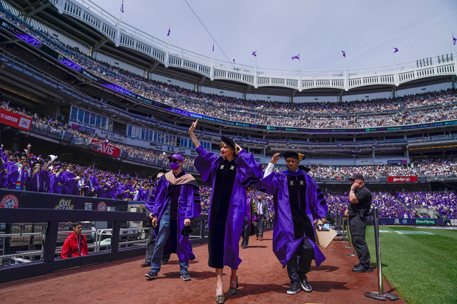 Taylor Swift, center, waves to graduates as she participates in a graduation ceremony for New York University at Yankee Stadium in New York, Wednesday, May 18, 2022. (AP Photo/Seth Wenig)