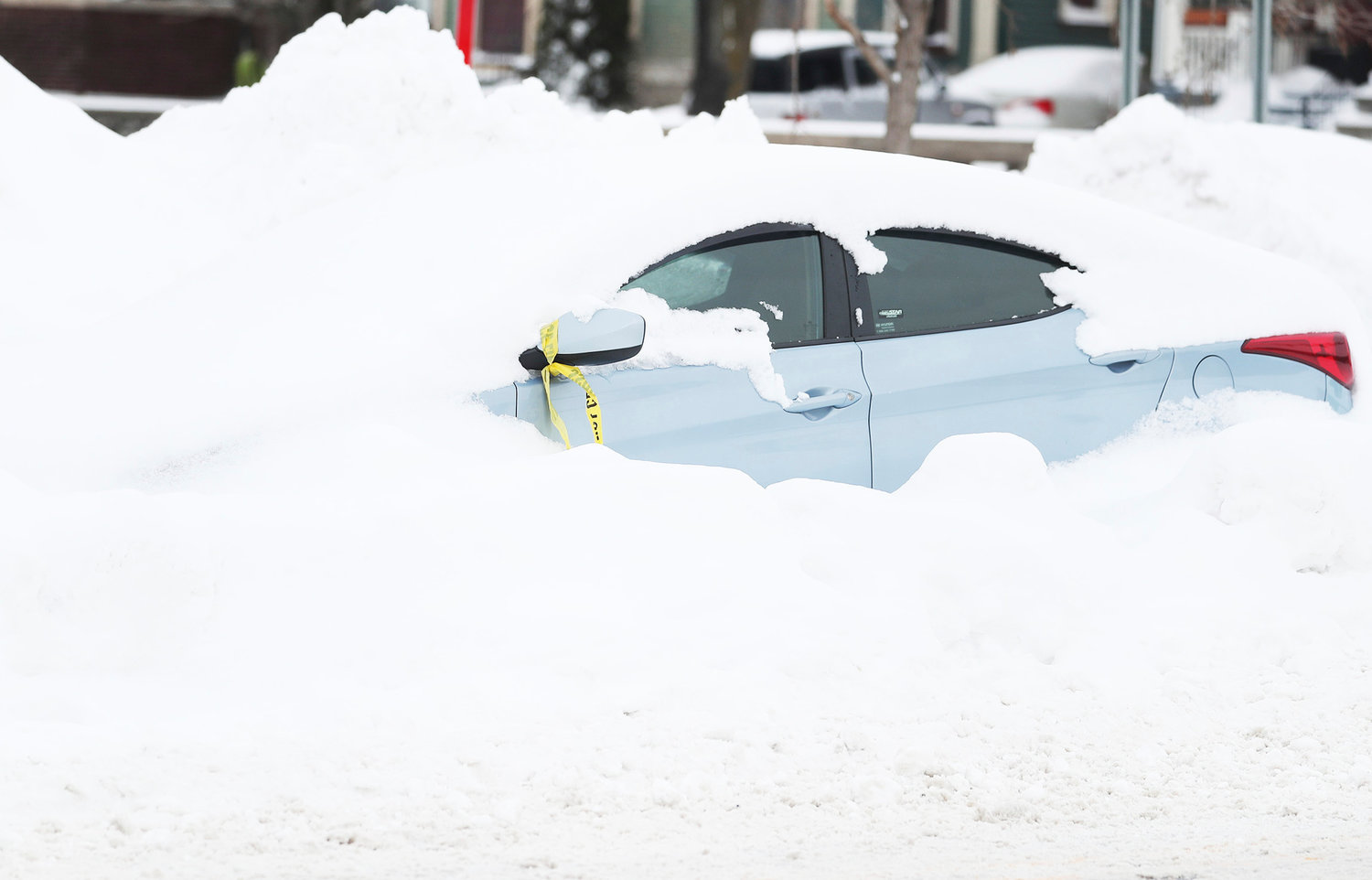 An abandoned car is covered in snow on Main Street in Buffalo on Tuesday, Dec. 27, days after a blizzard hit four Western New York counties.