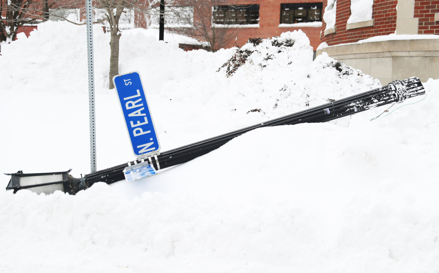 A North Pearl street sign is knocked down following heavy winds in Buffalo, N.Y., on Tuesday, Dec. 27, 2022. The wind was part of a blizzard that hit four Western New York counties. (Joseph Cooke/The Buffalo News via AP)