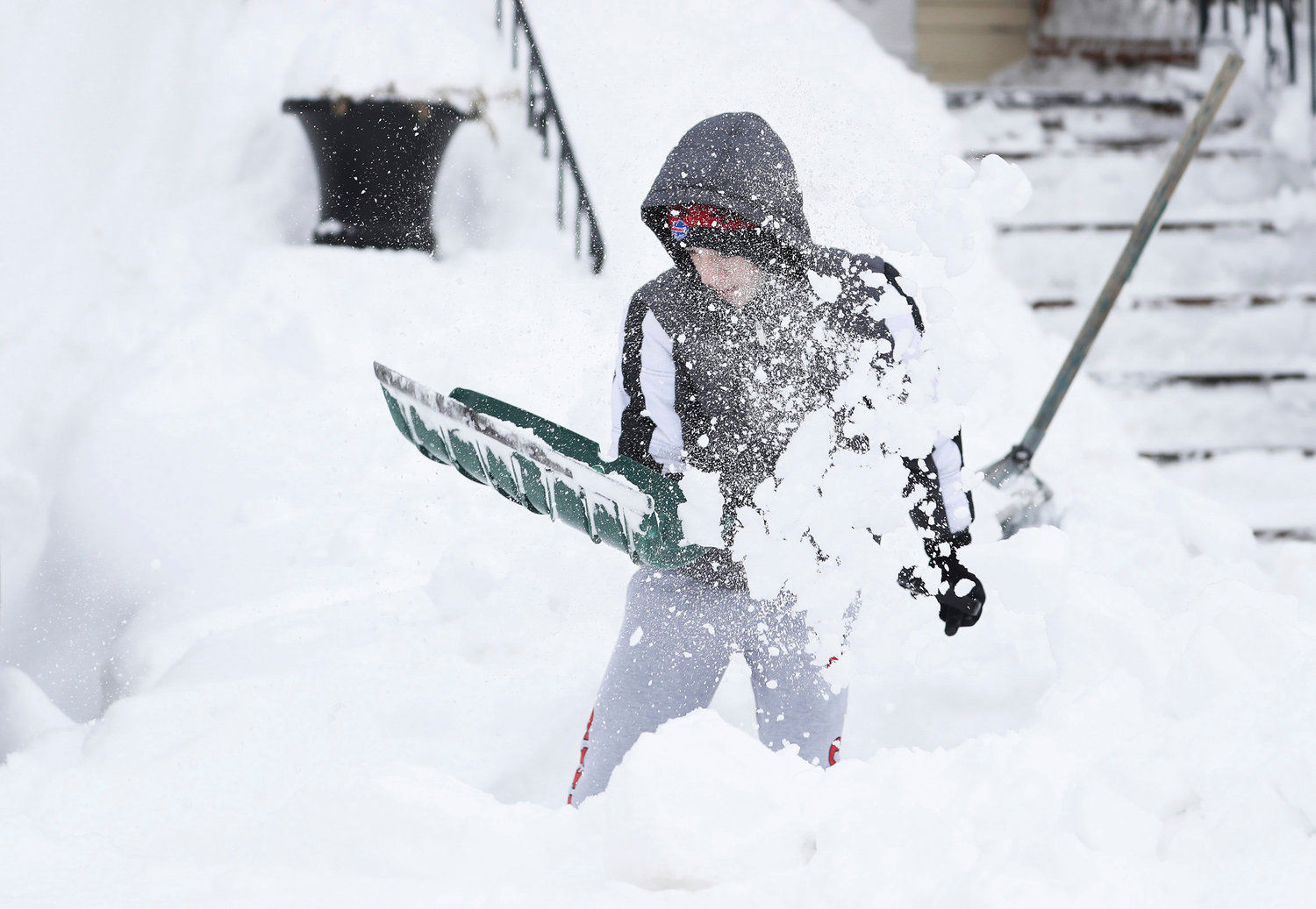 Angelo Milioto, 13, shovels snow away from around his home in Buffalo, N.Y., on Tuesday, Dec. 27, 2022. Clean up is currently under way after a blizzard hit four Western New York counties. (Joseph Cooke/The Buffalo News via AP)