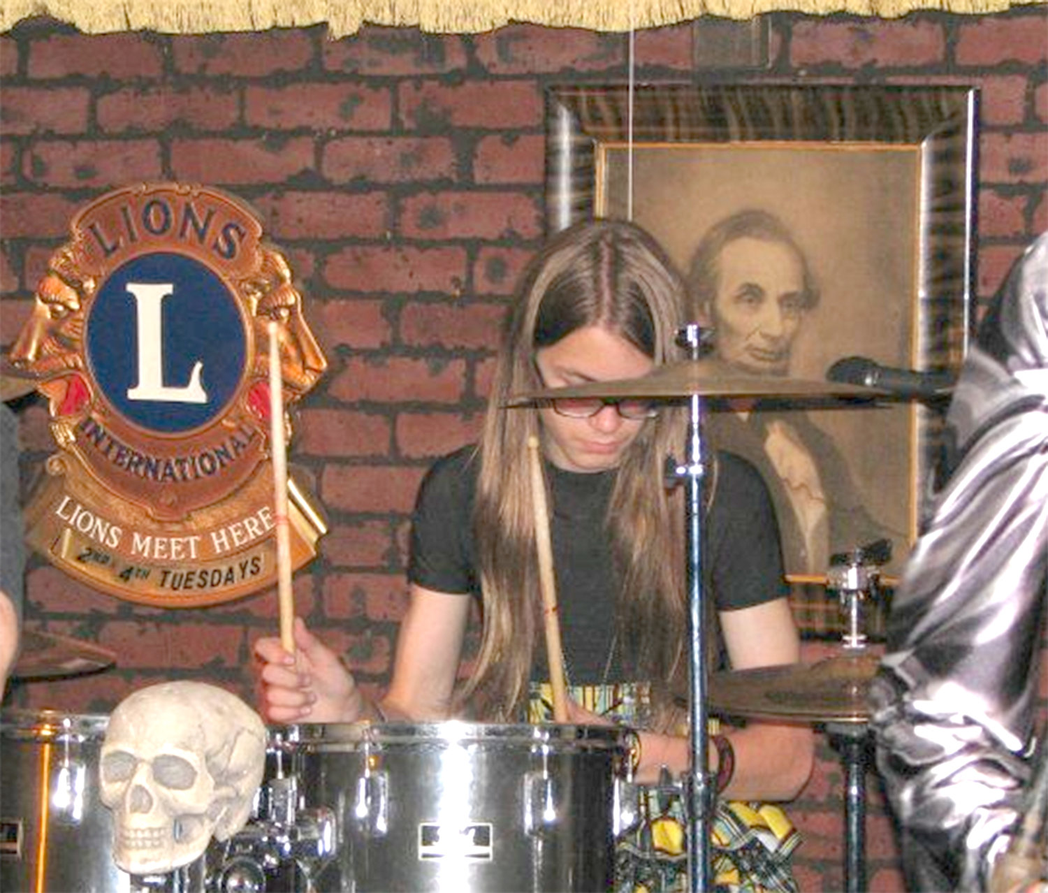 Gunnar Coston plays drums during a 2013 concert at the former Madison House Restaurant in Oneida, flanked by a photo of President Abraham Lincoln.