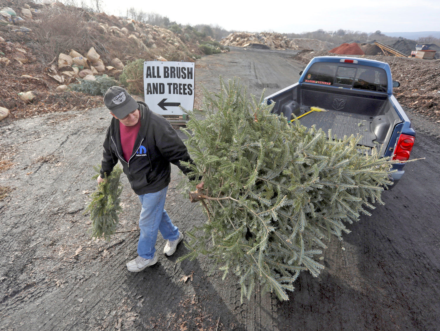 George Highhouse, of Scranton, brings his Christmas tree and a wreath to Lackawanna County Recycling in Dunmore, Pa., on Jan. 2, 2019.