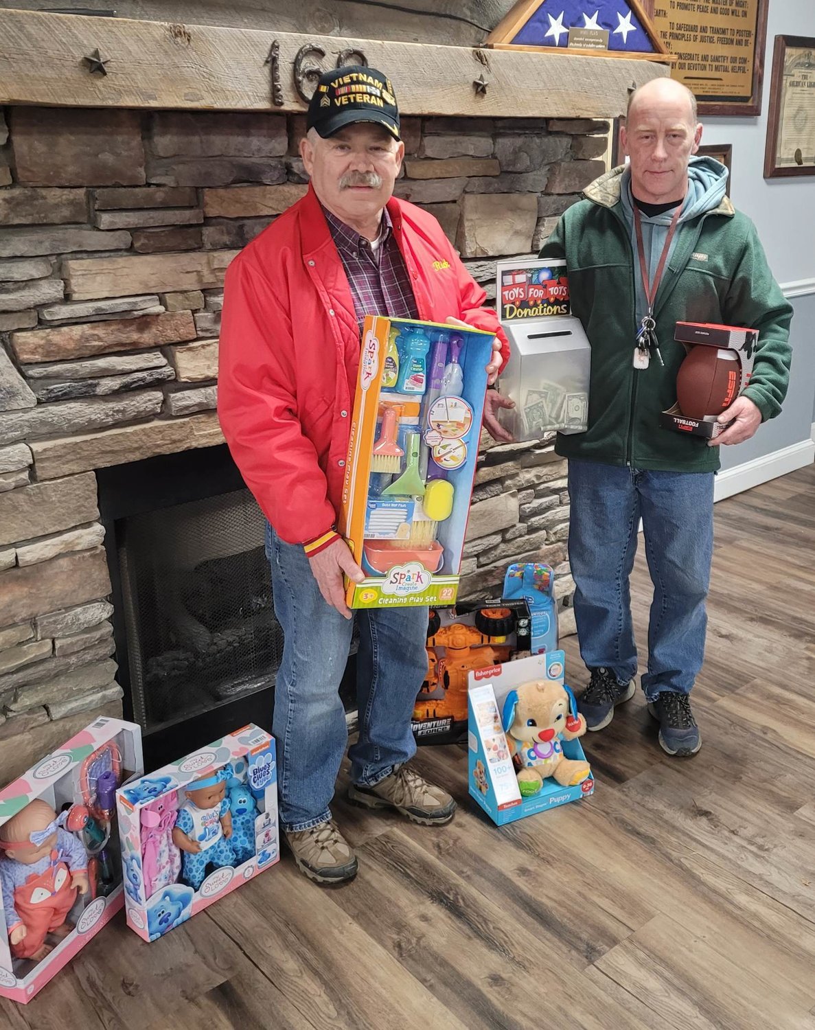 The Marine Corps League’s Rick Warham, left, and Oneida American Legion Post 169 Commander Jim Roberts pose recently with items donated to the post’s Toys for Tots collection.