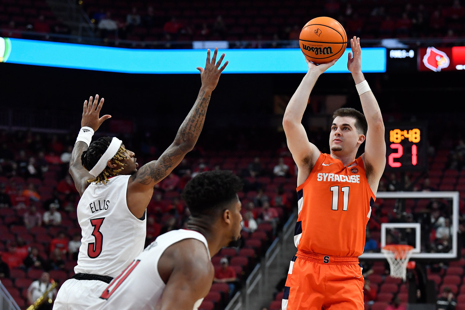 Syracuse guard Joe Girard III (11) shoots over Louisville guard El Ellis (3) during the first half of Tuesday night's game in Louisville, Ky. Girard III scored 28 points as the Orange survived a frantic final eight seconds to edge the Cardinals 70-69.