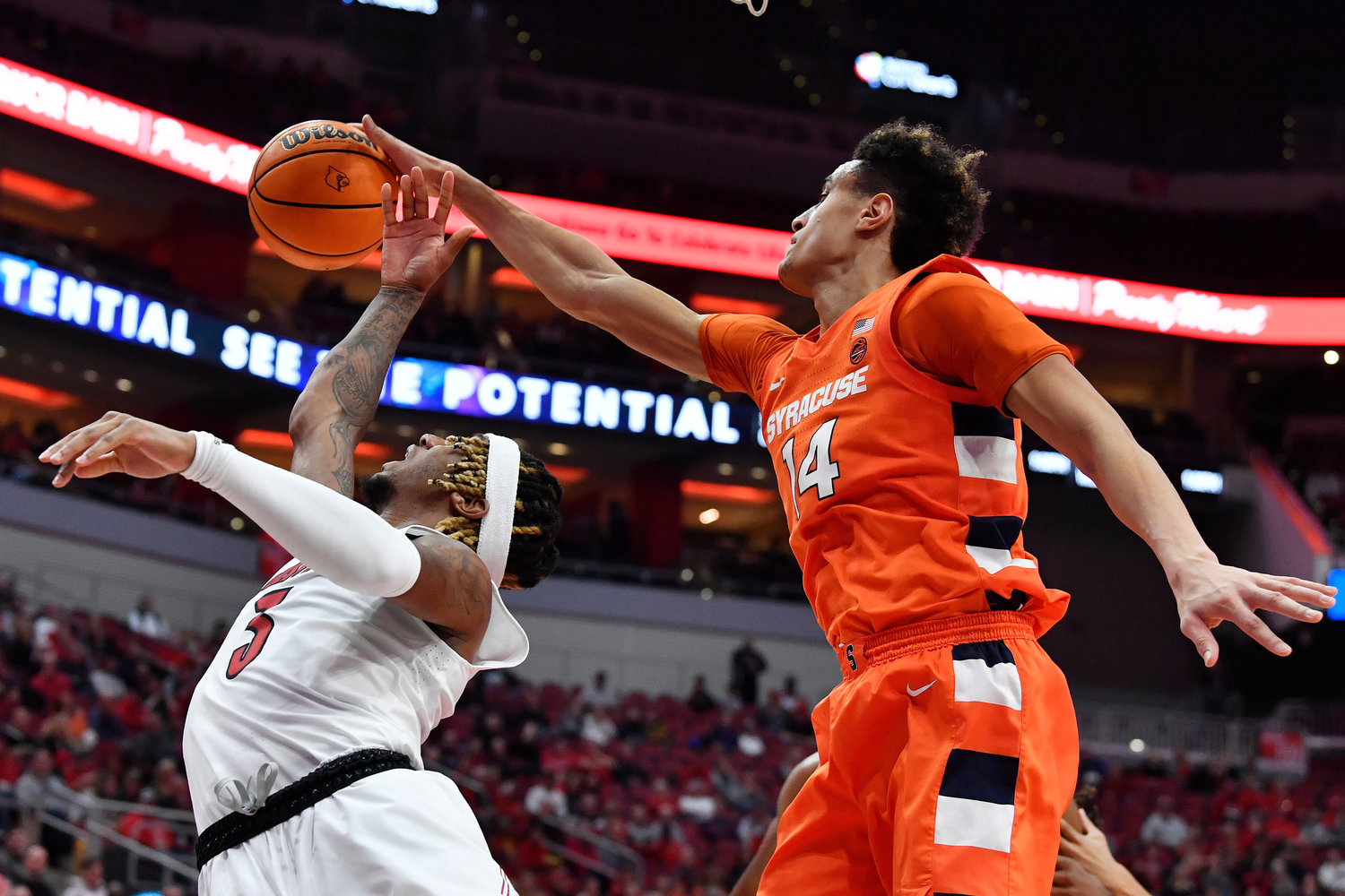 Syracuse center Jesse Edwards (14) blocks the shot of Louisville guard El Ellis (3) during the second half of Tuesday night's game in Louisville, Ky. Syracuse won 70-69.