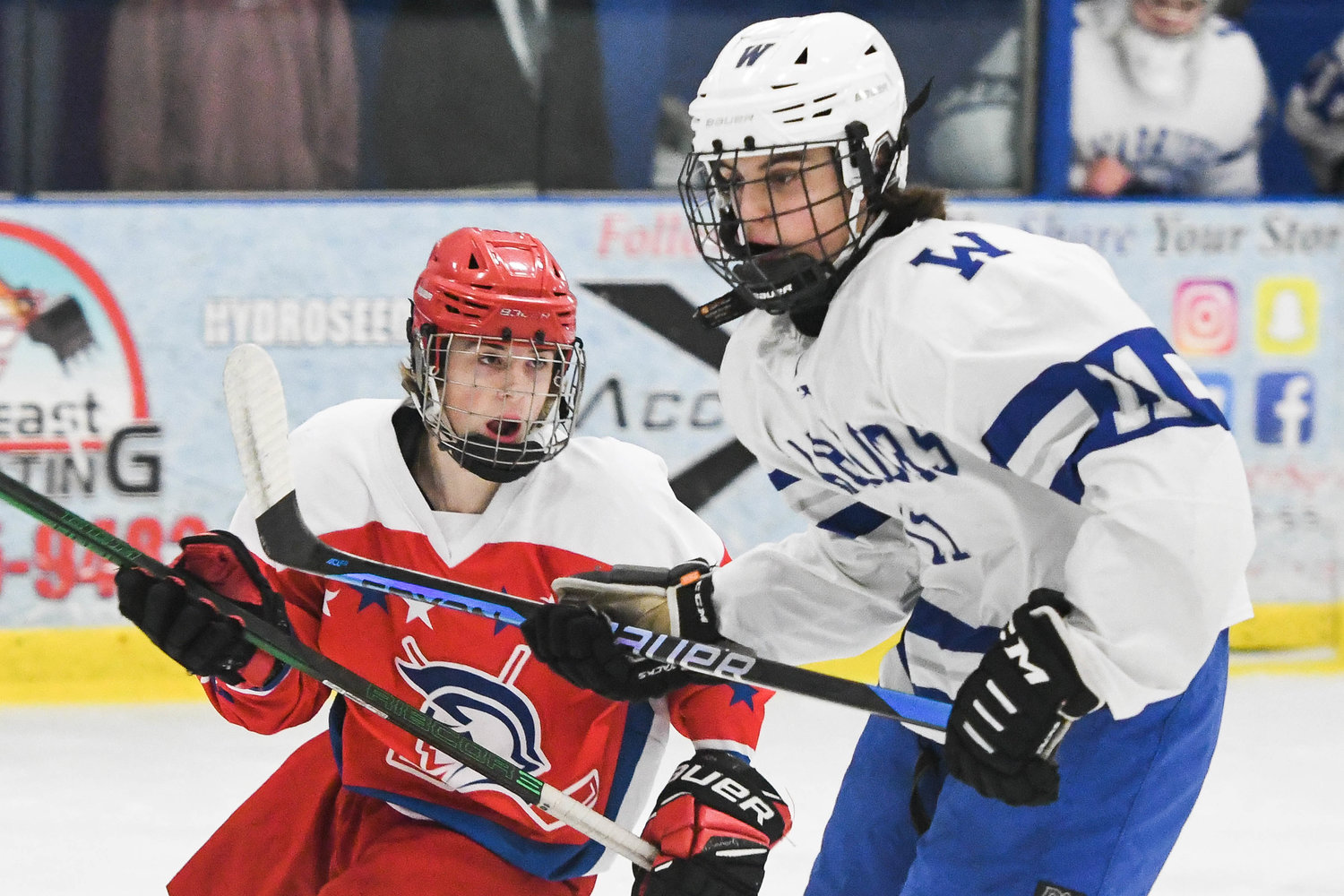 New Hartford’s Jake Hill, left, looks for a pass as Whitesboro’s Brett Purner defends in front of the net on Tuesday at the Whitestown Community Ice Rink. New Hartford got the game’s only goal for a 1-0 victory.