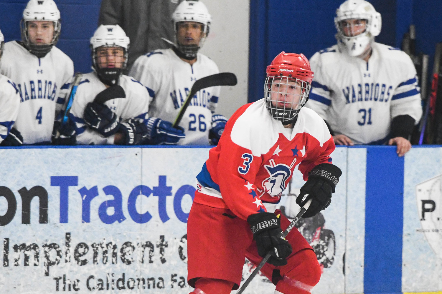 New Hartford player Garrett Smith flips the puck over the blue line against Whitesboro on Tuesday at the Whitestown Community Ice Rink. The Spartans won 1-0 on the road.
