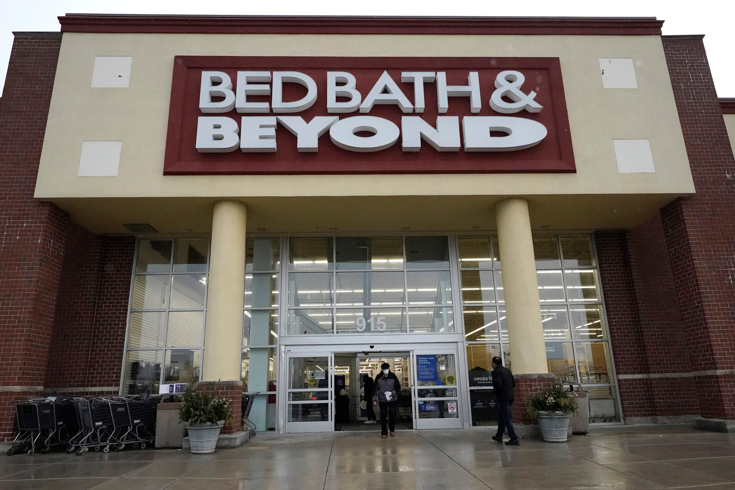Shoppers enter and exit a Bed Bath & Beyond in Schaumburg, Ill., Jan. 14, 2021. Struggling Bed Bath & Beyond warned on Thursday that there's substantial doubt about the company's ability to continue as a "going concern" even as it continues to look at options like refinancing its debt or restructuring its business in bankruptcy court.