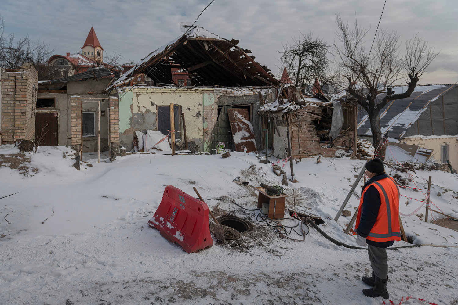 Workers of communal service clear the area near buildings impacted by Russian missile shelling in Kyiv, Ukraine, Wednesday, Jan. 11, 2023.