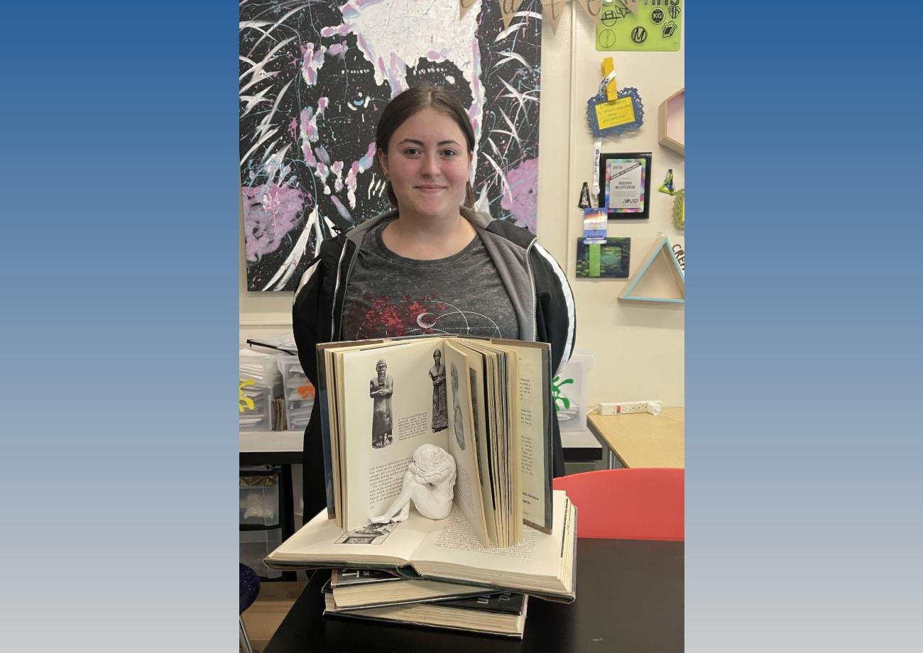 Herkimer Central School District senior Hannah Minguela won a Silver Key Award in the 2023 Central New York Scholastic Art Awards. She poses here with her winning piece, a sculpture she made out of clay and recycled books.