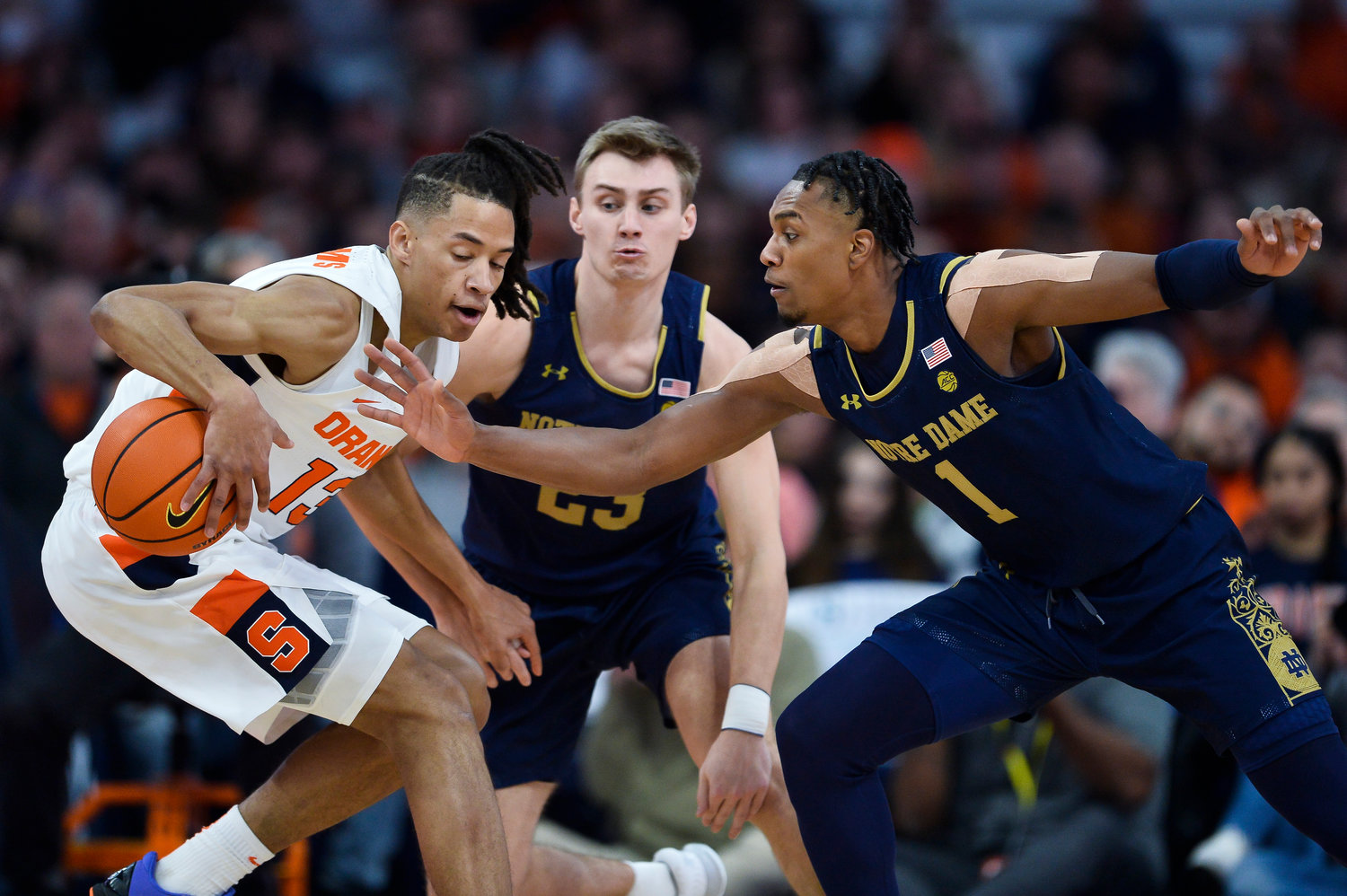 Syracuse forward Benny Williams, left, shields the ball from Notre Dame guard JJ Starling during the first half of Saturday night's game in Syracuse.