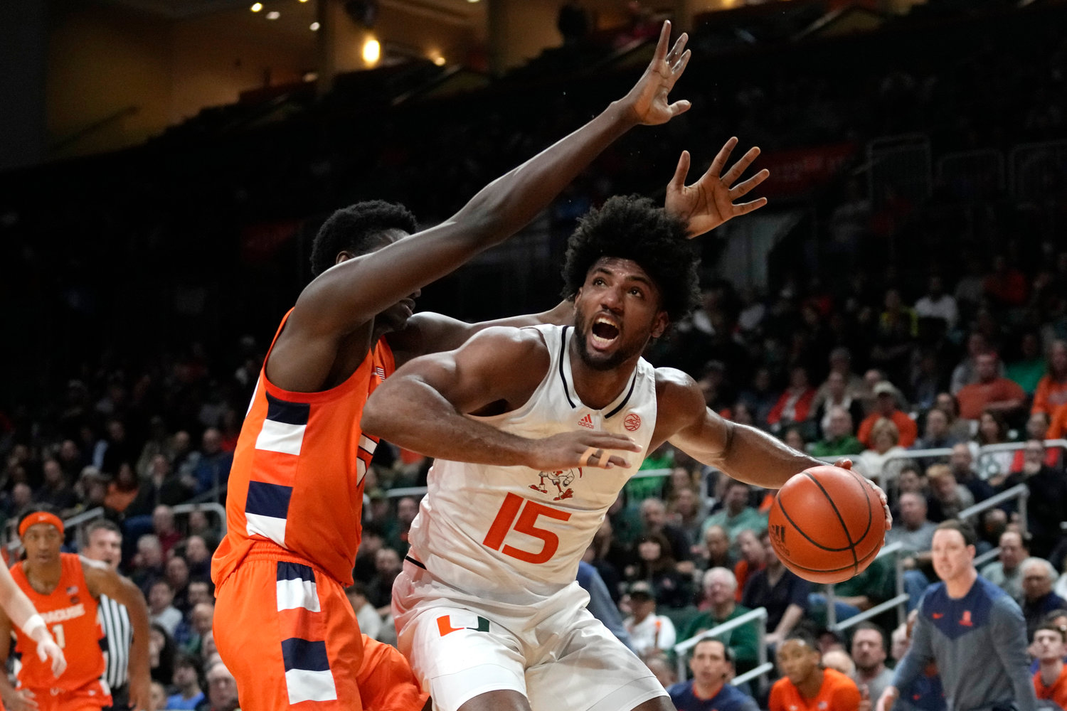 Miami forward Norchad Omier (15) drives to the basket as Syracuse center Mounir Hima defends during the first half of Monday night's game in Coral Gables, Fla. The Orange lost 82-78.
