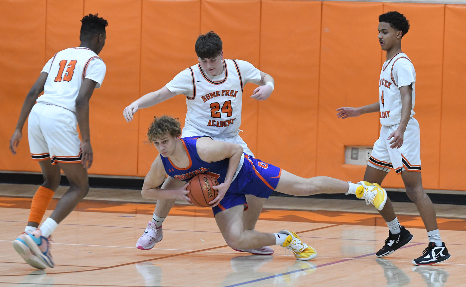 Oneida's Austin Degroat falls to the floor looking to pass the ball while defended by Rome Free Academy players. From left are Deandre Neal, Luke Hammon and Surafia Norries. RFA won the home Tri-Valley League game Friday night 95-80.