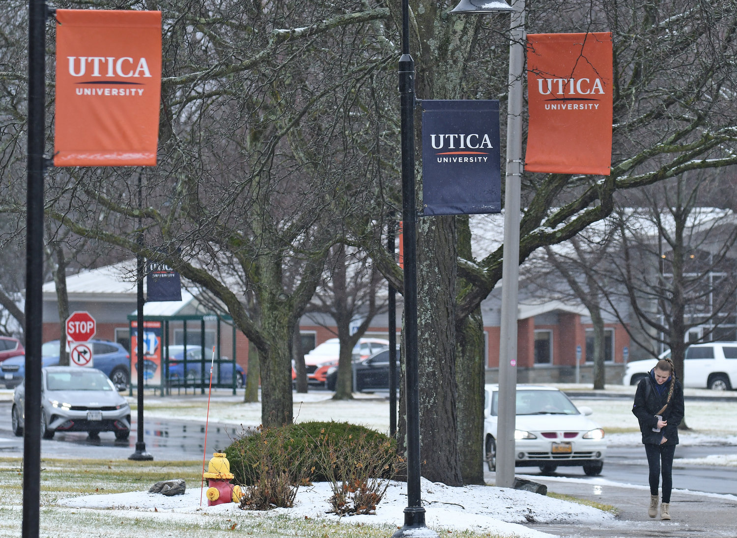Utica University banners are seen on campus Friday, Jan. 20 while a student walks along the sidewalk in Utica.